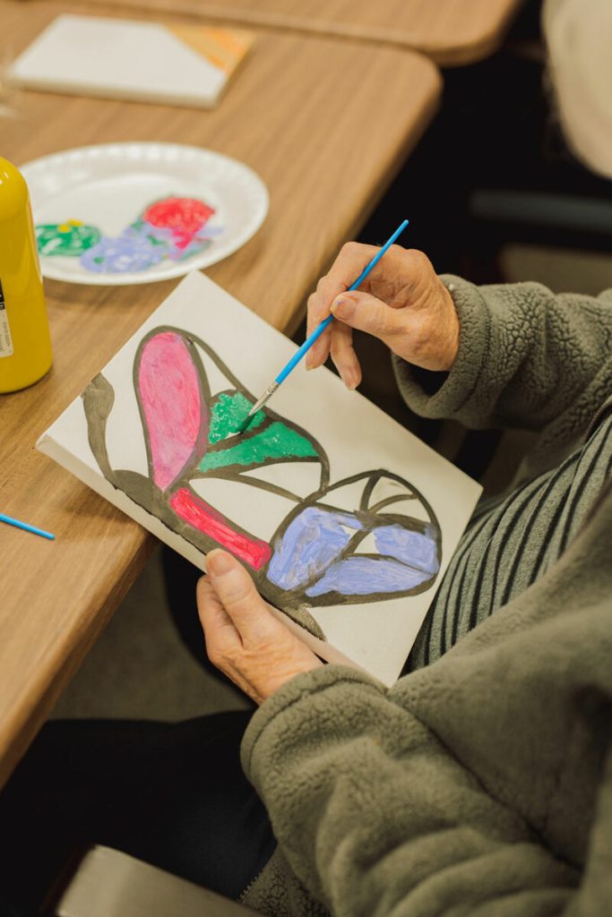 A resident painting during an afternoon activity